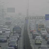 Industrial malaise: A Beijing highway is enveloped by thick smog last month as China\'s pollution worsens, and spreads. | KYODO