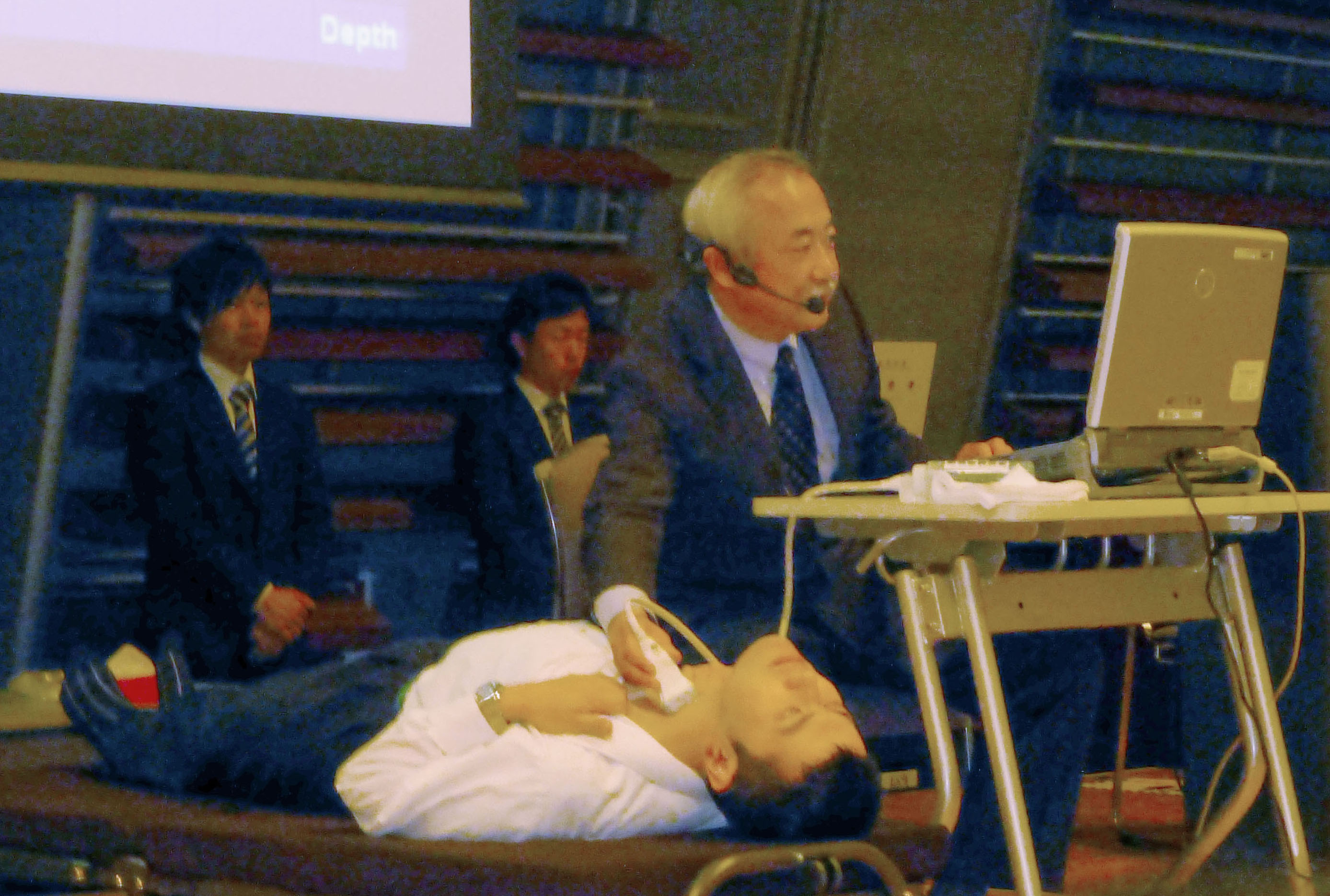 Fallout check: Professor Shinichi Suzuki of Fukushima Medical University, who has been involved in thyroid checks on local children exposed to the nuclear plant disaster, demonstrates the examination process during a meeting with parents in November in Koriyama, Fukushima Prefecture. | KYODO