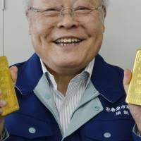 Prize catch: Kunio Suno, the president of a fish market in Ishinomaki, Miyagi Prefecture, shows off a donated pair of gold bars worth &#165;10 million Thursday. | KYODO