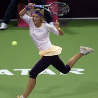 On the run: Victoria Azarenka hits a return against Agnieszka Radwanska during their semifinal match at the Qatar Total Open on Saturday. Azarenka won 6-3, 6-3. | AP