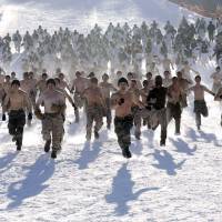 Cold war: Shirtless South Korean Marines and their U.S. counterparts run on a snow-covered slope during a joint winter military exercise in Pyeongchang, east of Seoul, on Thursday. More than 400 marines from the two countries are participating in the exercise, which began Monday and ends Feb. 22. | AP