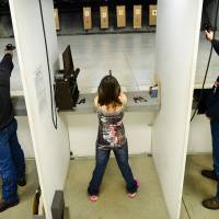 Aiming high: Two men and a girl take part in a shooting competition at the Red River Regional Marksmanship Center on Tuesday in West Fargo, North Dakota &#8212; one of the gun-friendliest states in the U.S. | THE WASHINGTON POST