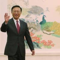 Changing times: Chinese Foreign Minister Yang Jiechi waves to reporters during a news conference at the Great Hall of the People in Beijing on March 9. Inset: Wang Yi. | AP