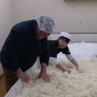 Hands-on: Old Nic helps ferment rice on a visit to fifth-generation sake maker Iwao Niizawa. | TAKUMI TOCHIZAWA