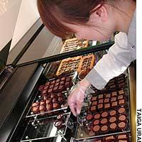 A clerk arranges chocolates in a display case at Le Chocolatier Takagi in Tokyo\'s Setagaya Ward. | JT: YOSHIAKI MIURA