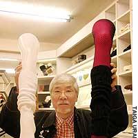 Akira Tokita, president of sock maker Browndoll Co., shows off a \"loose sock\" (left) and pantyhose ensconced in a leg warmer. | PHOTO COURTESY OF FULLCAST CO.