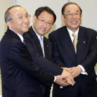 Hands-on experience: Akio Toyoda (center), then executive vice president of Toyota Motor Corp., joins hands with then President Katsuaki Watanabe (left) and Chairman Fujio Cho at a January 2009 news conference in Tokyo to announce Toyoda\'s appointment to the top spot. | AP PHOTO
