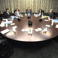 Bank on it: Bank of Japan Gov. Masaaki Shirakawa (center) sits with his Policy Board members at the start of their April meeting. | BLOOMBERG PHOTO