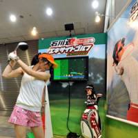 Fine form: A model tries out Epoch Co.\'s virtual golf game, Ryo Ishikawa Excite Golf, at Tokyo Big Sight on Thursday. | YOSHIAKI MIURA PHOTO