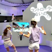 Two women play a beach volleyball video game on Microsoft\'s Xbox 360 console with the new Kinect camera-sensor system at the Tokyo Game Show at Makuhari Messe hall in Chiba on Thursday. | YOSHIAKI MIURA PHOTO