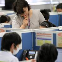 Dialing in: Tokyo Electric Power Co. employees handle telephone calls at its Fukushima Nuclear Compensation Office in Tokyo earlier this month. | BLOOMBERG