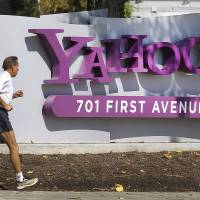 Acquisition target: A jogger passes a sign outside Yahoo! Inc.\'s headquarters in Sunnyvale, California, on Oct. 13. | BLOOMBERG PHOTO