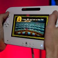 Pushing buttons: Nintendo\'s Wii U video game console is demonstrated at the Nintendo booth at the 2011 Electronic Entertainment Expo in Los Angeles last June. | AP