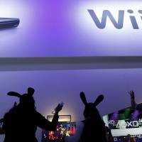 Hare-brained?: People sporting rabbit ears play with  Wii U consoles during the E3 Expo in Los Angeles on June 5. | BLOOMBERG