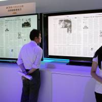 The last word in TV tech: A visitor at the CEATEC Japan 2012 high-tech exhibition reads a newspaper on Sony Corp.\'s new 4K liquid crystal display TV set in Makuhari Messe in Chiba Prefecture on Tuesday. | BLOOMBERG