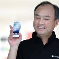Betting big: Masayoshi Son, chairman and chief executive officer of Softbank Corp., shows off an Apple iPhone 5 during its launch in  Tokyo on Sept. 21. | BLOOMBERG