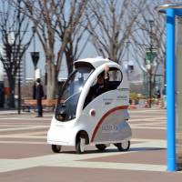 One-seater: Hitachi Ltd.\'s new Robot for Personal Intelligent Transportation System goes on a test run in Tsukuba, Ibaraki Prefecture, on Tuesday. The ROPITS can be programmed to pick up and drop off a passenger. | AFP-JIJI