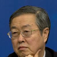 Zhou Xiaochuan, governor of the People\'s Bank of China, attends a press conference Wednesday. He said the central bank will maintain its current monetary policies. | AP