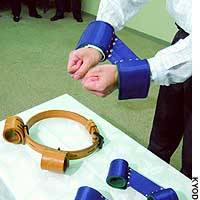 A new type of manacle unveiled at the Justice Ministry will replace leather restraining devices like the brown one on the table. | KYODO ILLUSTRATION