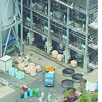 Employees mill about at a chemical plant in Matsuyama, Ehime Prefecture, after several workers fell ill due to a carbon monoxide leak. | HIROSHI MATSUBARA PHOTO
