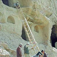 Researchers and local workers prepare to examine ancient caves in Bamiyan, central Afghanistan. Below, a fragment of seventh-century Buddhist scripture that was found by Japanese experts. | PHOTOS FROM THE NATIONAL RESEARCH INSTITUTE FOR CULTURAL PROPERTIES>