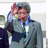 Prime Minister Junichiro Koizumi waves Sunday at Tokyo\'s Haneda airport as he boards a government jet bound for Bangkok, where he will attend an annual APEC summit. | YUMI WIJERS-HASEGAWA PHOTO