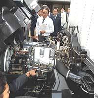 An official representing a 10-company consortium showcases a clean-air engine for trucks during a recent media preview in Tokyo. The engine is powered by dimethyl ether produced from natural gas. | &#160; PHOTO COURTESY OF BANDAIJIN ECO GAIDO NO KAI (AN ASSOCIATION OF BANDAI ECOTOUR GUIDES)