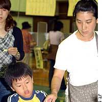A boy helps his mother vote in the House of Councilors election Sunday in Minato Ward, Tokyo. | PHOTO COURTESY OF TAKAHIKO ISHIDA