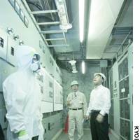 Transport Minister Kazuo Kitagawa (right) inspects walls and a ceiling with asbestos insulation at a former Japan Post branch in Tokyo\'s Otemachi district. | CULTURAL AFFAIRS AGENCY PHOTO