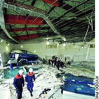 Rescue workers in Sendai stand amid the debris of a ceiling that collapsed Tuesday at an indoor swimming pool following a strong earthquake. | PHOTO COURTESY OF THE CULTURAL AFFAIRS AGENCY