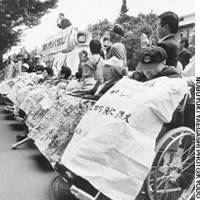 A photo by Nobuyuki Yaegashi in October 1995 shows former Hansen\'s disease patients from Taiwan and South Korea holding a rally outside the Tokyo District Court to demand Japan compensate them for their forced segregation from society. | JAPAN COAST GUARD PHOTO/KYODO
