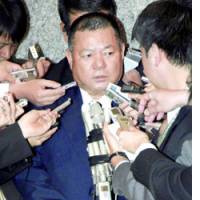 Nago mayor Yoshikazu Shimabukuro faces reporters in Tokyo after talks with central government officials on the Futenma base relocation plan. | KYODO PHOTO