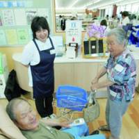 An elderly couple relax Saturday at a Lawson Inc. test outlet catering to the elderly. | KYODO PHOTO
