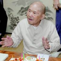 Tomoji Tanabe, the oldest man in Japan, celebrates his 111th birthday with a cake at his home Monday. | KYODO PHOTO