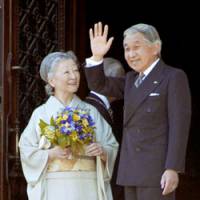 Emperor Akihito, standing with Empress Michiko, waves to a crowd at Uppsala University here on Wednesday. | KYODO PHOTO
