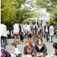 Waseda University students return to the Shinjuku campus in Tokyo Wednesday after the university resumed classes amid a national measles epidemic affecting mostly young people. | KYODO PHOTO
