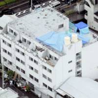 An aerial photo shows the condominium building rooftop in Moriguchi, Osaka Prefecture, where the decomposed body of a woman was found June 10 in a refrigerator. | KYODO PHOTO