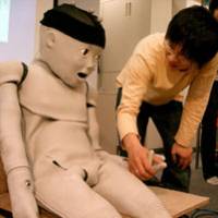 The Child-Robot with Biomimetic Body, or CB2, looks at Shuhei Ikemoto, an Osaka University student, during a demonstration at the school last week. | AP PHOTO