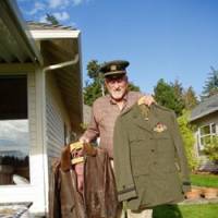 Lee Olson shows off his olive drab uniform, with navy wings, and wartime leather flight jacket at a friend\'s house last month in Maple Valley, Wash. | ERIC L. DUE PHOTO