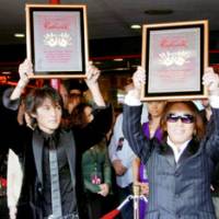 Vocalist Koshi Inaba (left) and guitarist Takahiro \"Tak\" Matsumoto of the pop group B\'z hold their commemorative placards Monday during their induction ceremony into Hollywood\'s Rockwalk of Fame. | KYODO PHOTO
