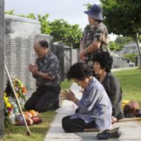 Guns long silent: Relatives of people who died during the Battle of Okinawa 63 years ago offer prayers to the dead Monday at a memorial park in Itoman, Okinawa Prefecture. | KYODO PHOTO