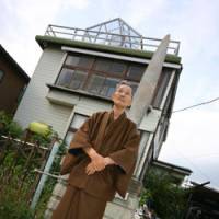 War trophy: Kokichi Nishimura stands in front of his house in Kazo, Saitama Prefecture. Protruding from his garden wall is a B-24 bomber\'s propeller that he had shipped back from Papua New Guinea. | DAVID MCNEILL