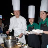 Chow time: Shoji Hirota, executive chef at Hotel Seiyo Ginza, serves curry made for a harvest festival at the Matsuya department store in Tokyo\'s Ginza district, with two Matsuya employees. | YOSHIAKI MIURA PHOTO