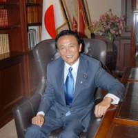 Seat at the top table: Taro Aso sits at the Liberal Democratic Party president\'s desk in the LDP headquarters in Tokyo on Monday. | YOSHIAKI MIURA PHOTO