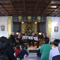 Live from London: Children and their families listen to a string quartet from the London Symphony Orchestra perform a free concert at a Tokyo care home Saturday. | MARIKO KATO