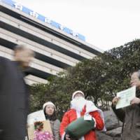 Not so jolly: A man dressed as Santa demands government steps to assist the jobless outside the Liberal Democratic Party\'s headquarters in Tokyo on Wednesday. | KYODO PHOTO