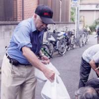 Dig in: Jean Le Beau of the NPO Sanyukai gives food to the homeless in Sanya, Tokyo, in 2008. | COURTESY OF SANYUKAI