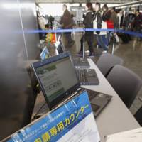 Last minute: A sign posted Monday at Narita International Airport alerts travelers to file last-minute online applications for short-term visits to the United States. | KYODO PHOTO