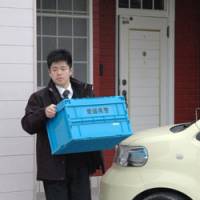 Eely feeling: A police investigator carries a box of items seized Thursday from the home of Shuto Oyama, former president of Sunrise Foods in Matsuyama, Ehime Prefecture. | KYODO PHOTO