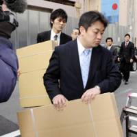 Boxed in: Prosecutors raid the Shinsei Kigyo advertising agency in Osaka on Thursday. | KYODO PHOTO